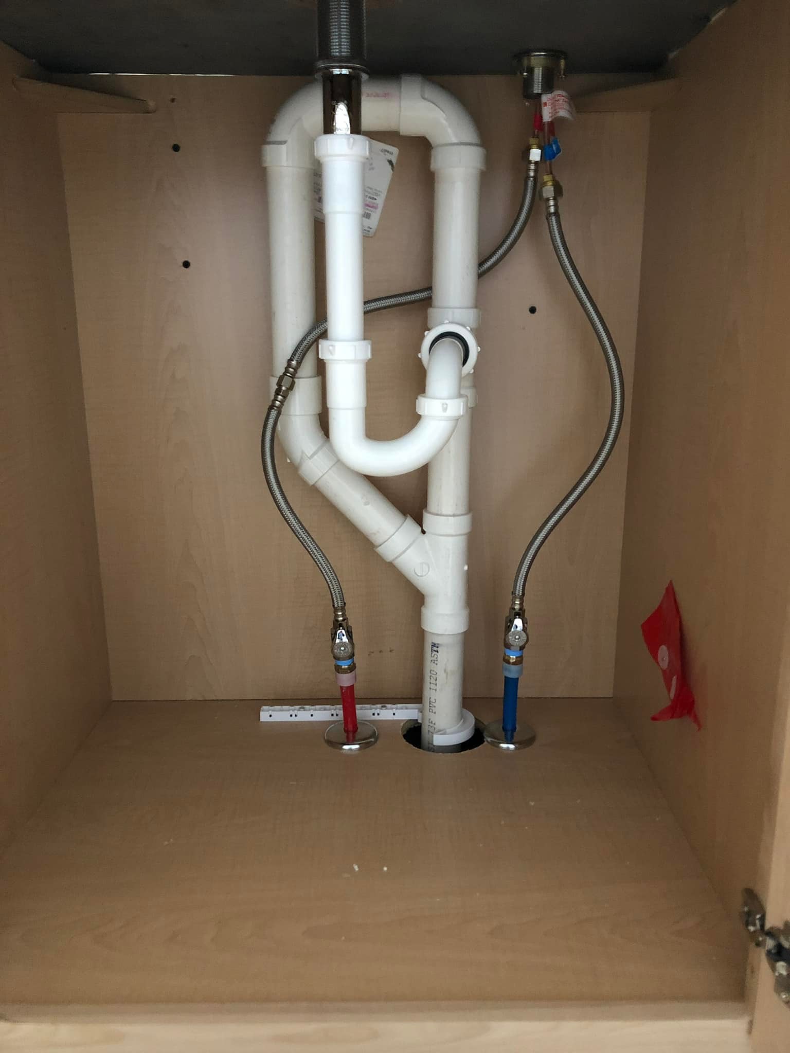 Clean PVC and braided supply-line work under the sink