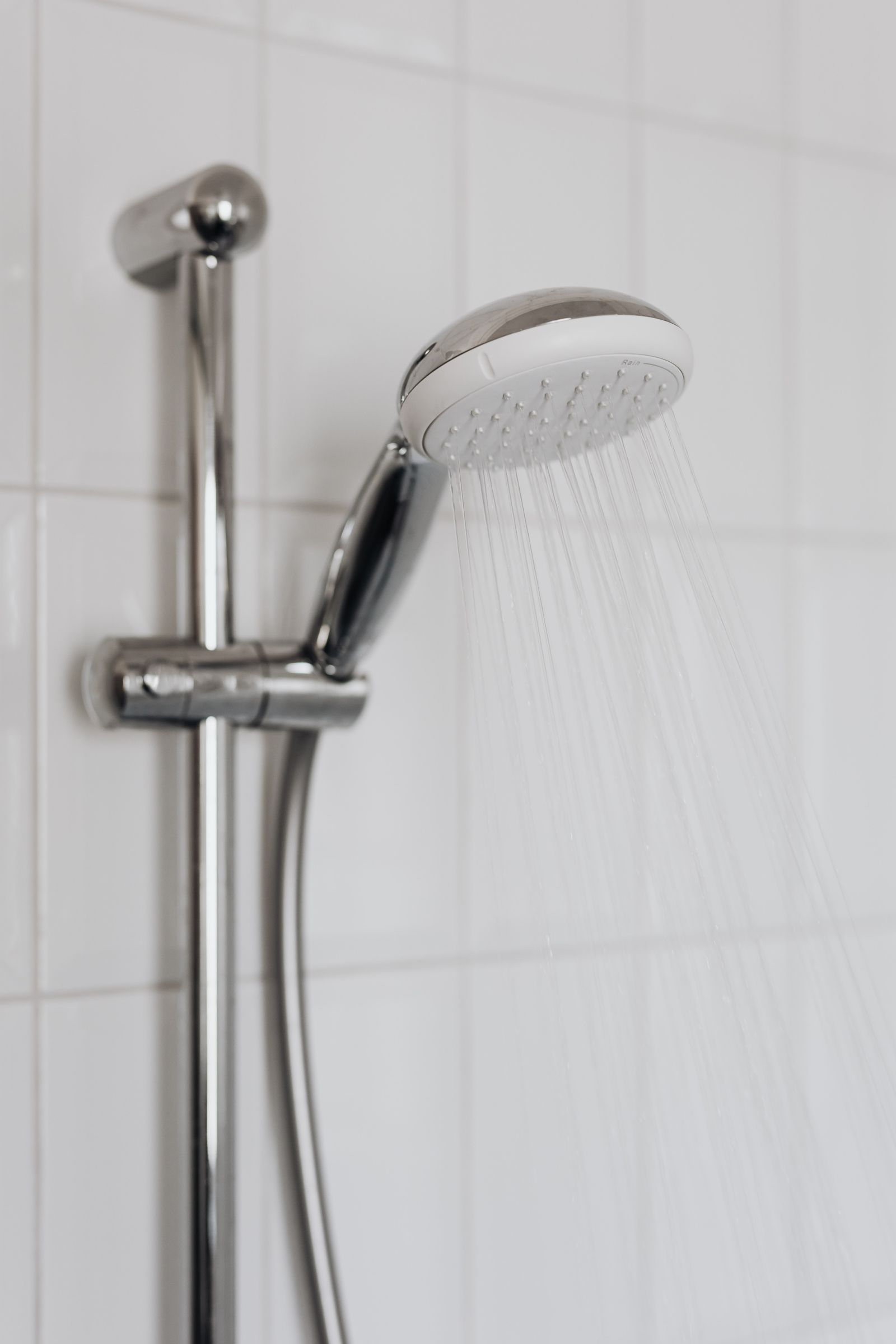 Chrome shower head — water flowing, done right