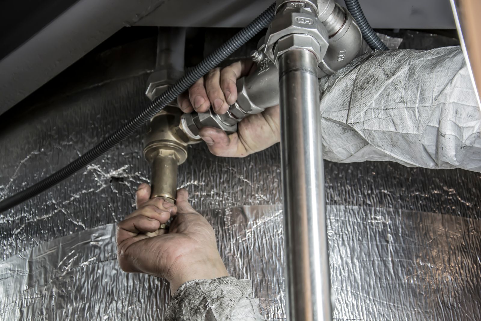 Boone Plumbing technician installing pipe fittings — professional plumber at work